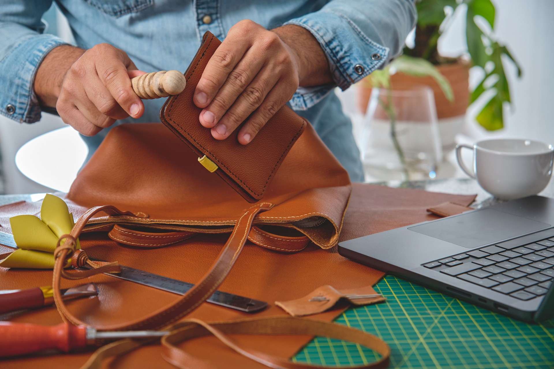 Leather craftsman working on handbag in workshop